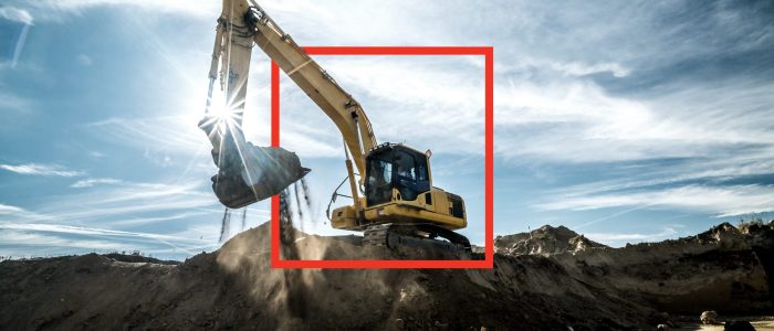 Construction - digger working at building site on sunny day